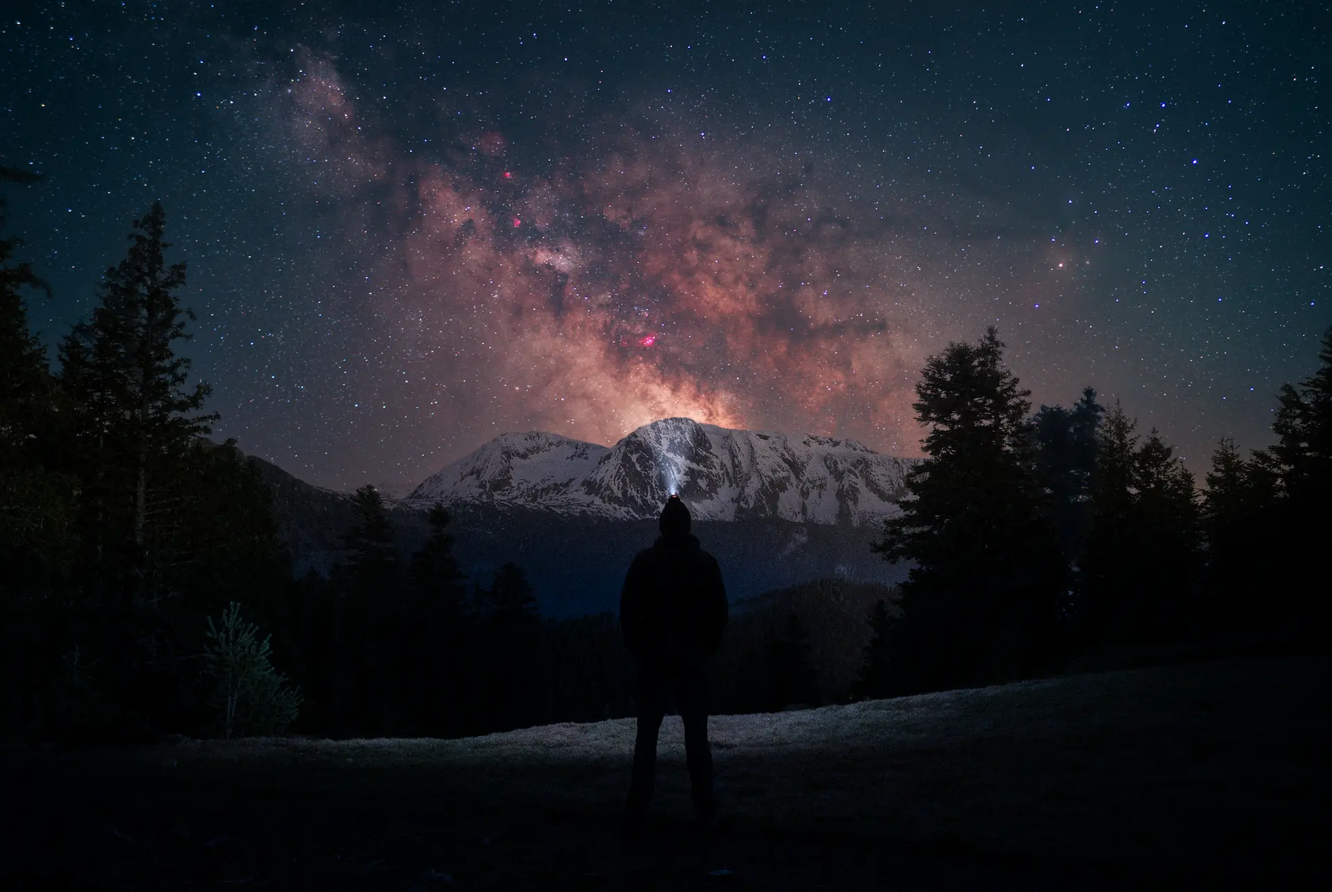 Un homme observe la voie lactée sous les étoiles